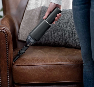 Using AeroSlim Hand Vac with crevice tool to vacuum couch cushion.