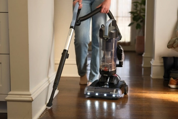 Using extension and tool to vacuum baseboards