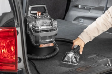 Using portable carpet cleaner to clean car interior