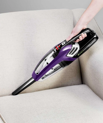 Using Pet Hair Eraser Hand Vac with Crevice Tool to Clean between couch cushions.