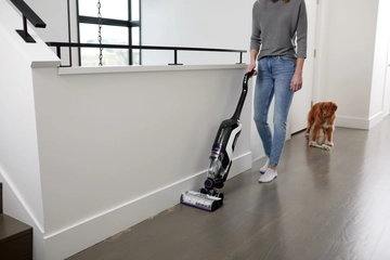 CrossWave Cordless Max Multi-Surface Wet Dry Vac vacuuming pet hair along baseboard.    