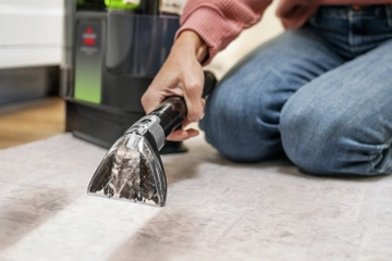 Using portable carpet cleaner to clean stain from upholstery