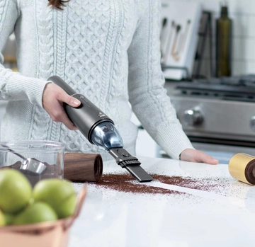 Using AeroSlim Hand Vac to vacuum coffee grounds from kitchen counter.