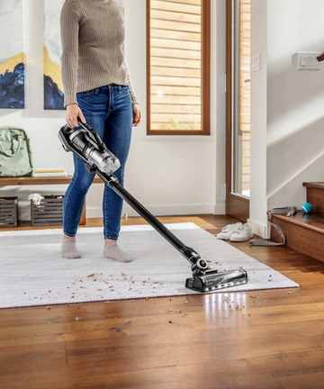Using ICONPET TURBO Cordless Stick Vac to vacuum area rug.