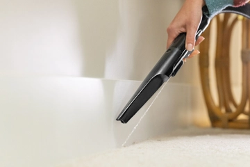 Using Spraying Crevice Tool to clean along baseboards.