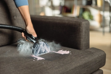 Little Green HydroSteam Portable Cleaner cleaning wet mess off couch.