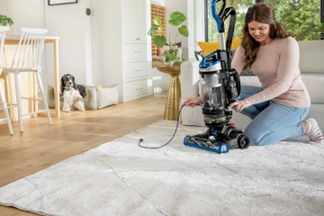 Rewinding cord back into machine of CleanView Swivel Rewind Vacuum.