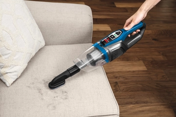 Using ReadyClean Cordless Stick Vac as a Hand Vac with combined crevice tool and dusting brush to vacuum couch cushion.