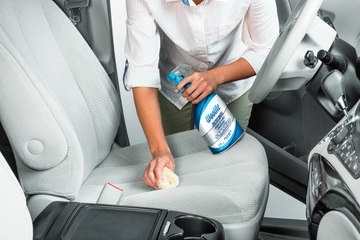 Woolite® Advanced Stain & Odor Remover + Sanitize being used to clean car seats.