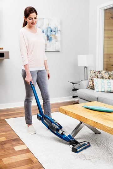 Using PowerSwift™ Ion Pet Cordless Sick Vac bending handle to vacuum under table.